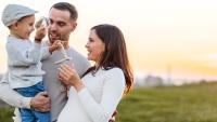 Happy family outdoors at sunset.